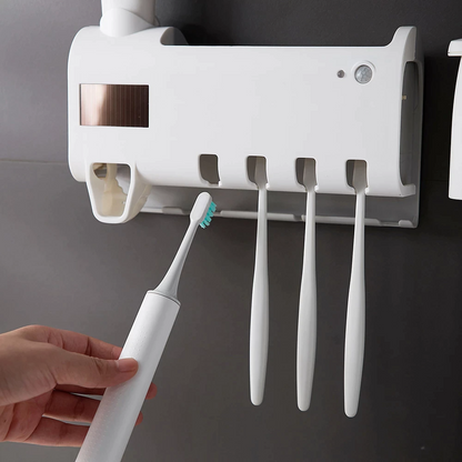 UV Light Sterilizer Toothbrush Holder Cleaner & Automatic Toothpaste Dispenser with toothbrushes mounted on the wall.