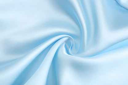 Light blue satin fabric swirled for wedding party satin robe, showcasing smooth texture and elegant drape.