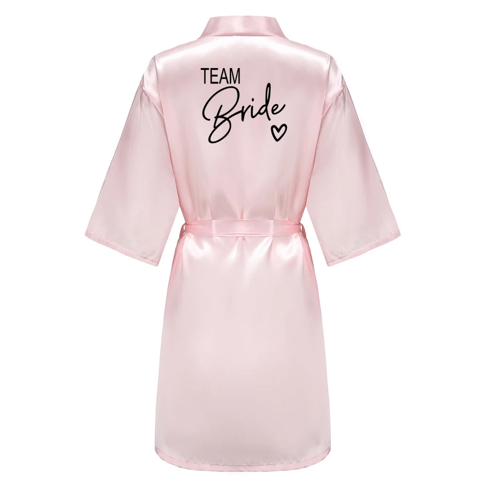 Bridesmaid satin robes featuring a pink satin kimono with 'TEAM Bride' written on the back, perfect for wedding celebrations.