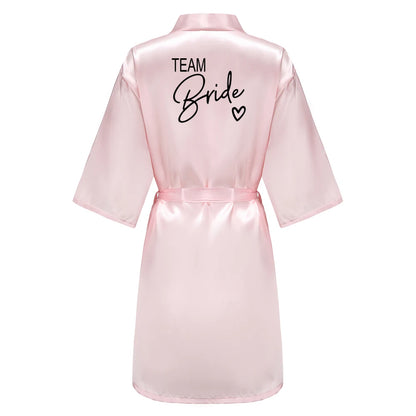 Bridesmaid satin robes featuring a pink satin kimono with 'TEAM Bride' written on the back, perfect for wedding celebrations.