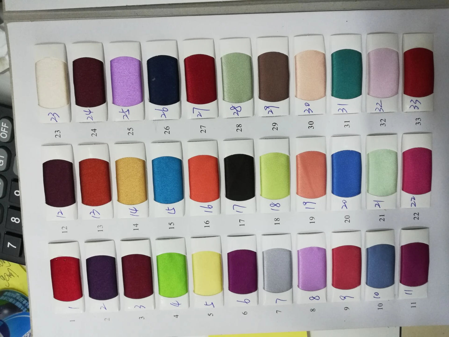 Color swatches of fabric for mermaid evening dresses in various shades including purple, red, green, and blue.
