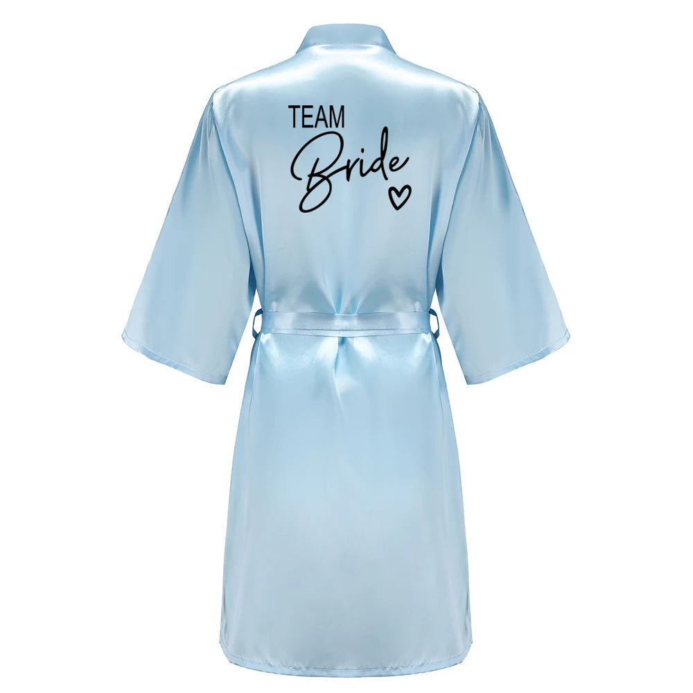 Bridesmaid satin robes featuring a light blue kimono-style bathrobe with 'TEAM Bride' lettering on the back.