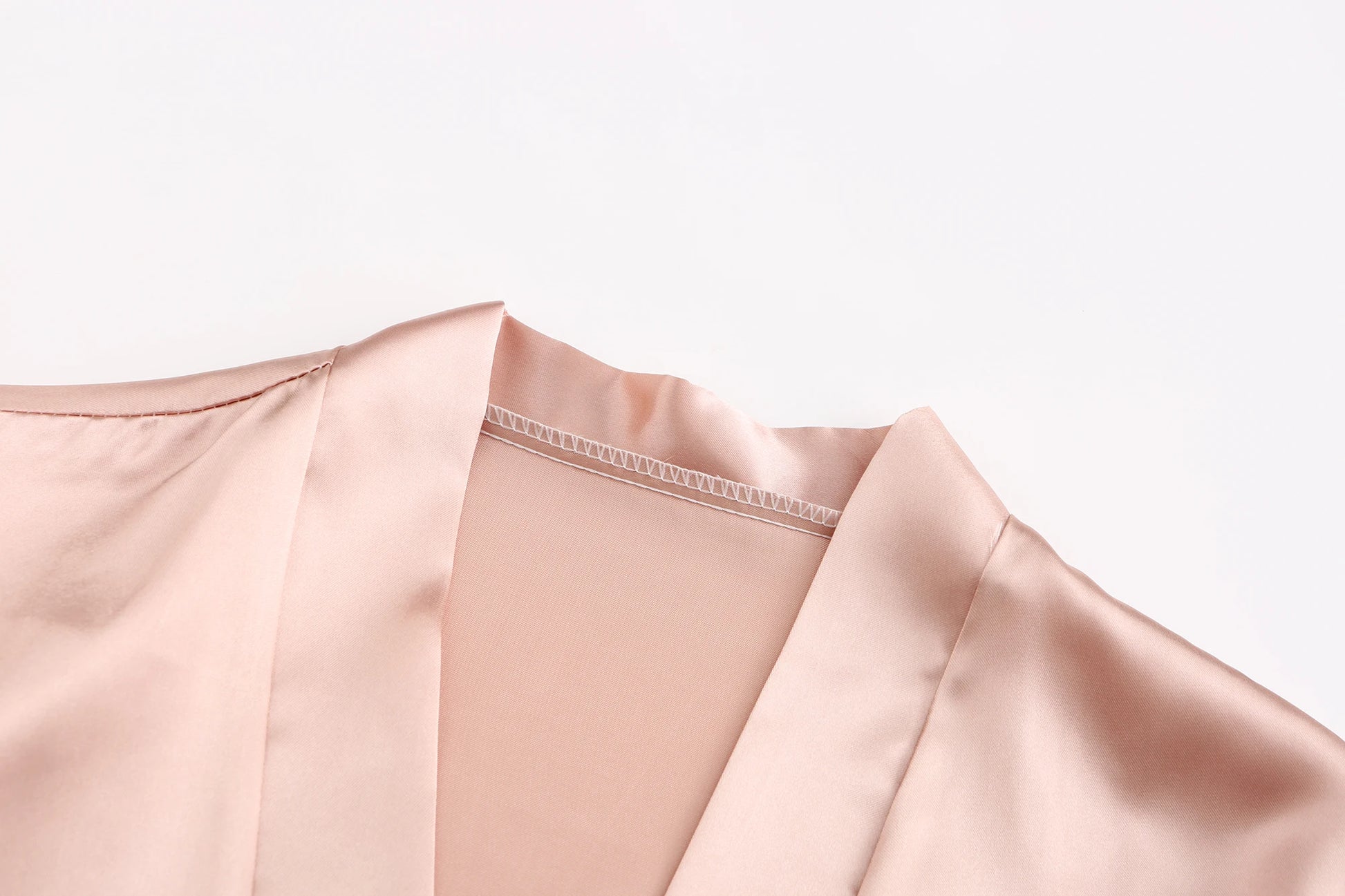 Close-up of the collar and neckline of a bridesmaid satin robe in soft pink, showcasing luxurious satin fabric.