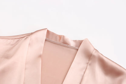 Close-up of the collar and neckline of a bridesmaid satin robe in soft pink, showcasing luxurious satin fabric.