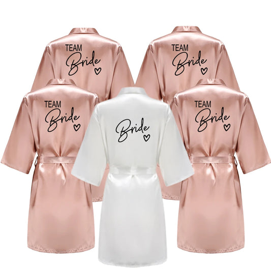 Bridesmaid satin robes featuring 'TEAM Bride' in black letters, available in various colors, perfect for wedding parties.