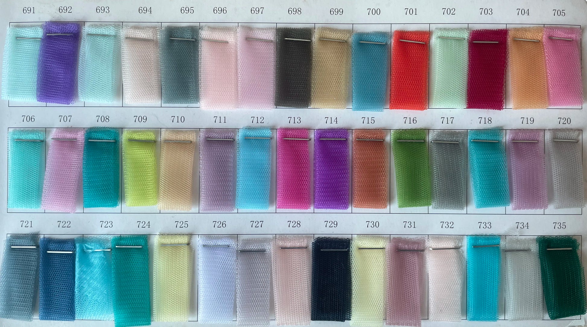 Color swatch samples for fabric options including various shades in tulle for asymmetrical prom gown.