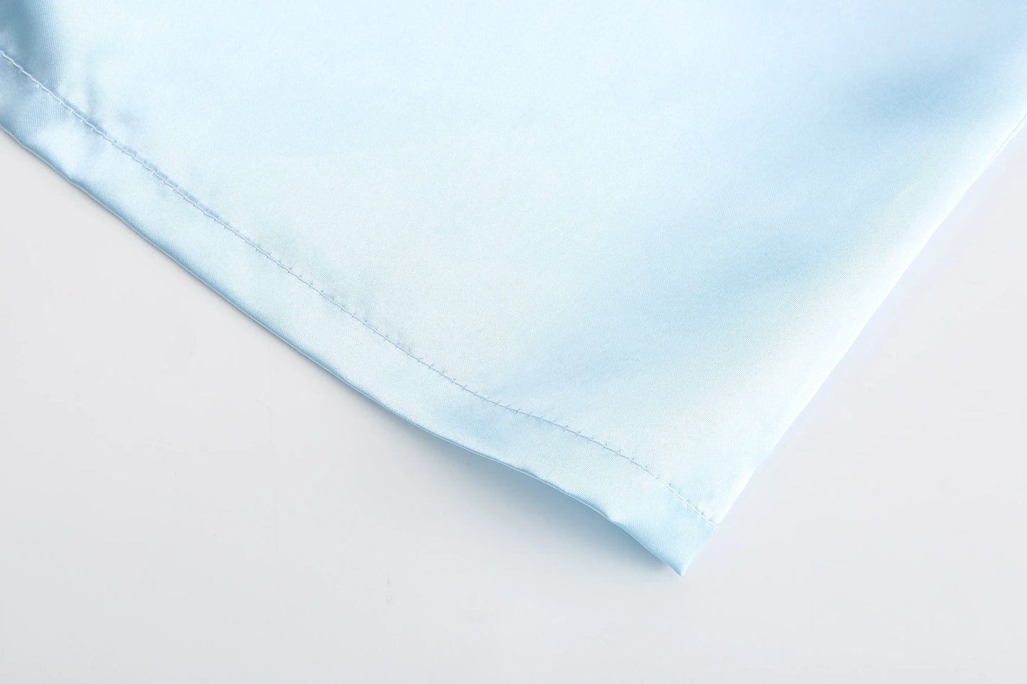 Light blue satin fabric detail for wedding party satin robe, showcasing smooth texture and soft finish.