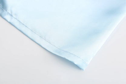 Light blue satin fabric detail for wedding party satin robe, showcasing smooth texture and soft finish.