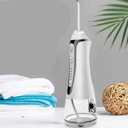 Portable Water Flosser And Pik For Dental Hygiene on a bathroom counter with towels and decor.